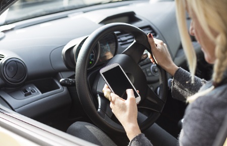 Woman sending text messages while driving.
